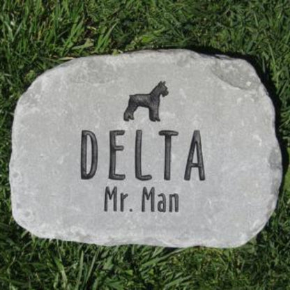 A personalized  stone dog memorial plaque engraved with a black dog silhouette, the name 'DELTA', and 'Mr. Man', placed on green grass.