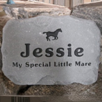 A personalized gray stone horse memorial engraved with the name 'Jessie', a small horse silhouette, and the phrase 'My Special Little Mare', displayed against a natural stone background.